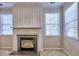 Living room showcasing a classic fireplace with decorative mantel and trim and two large sunny windows at 2357 Barrett Cottage Pl, Marietta, GA 30066