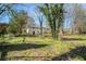 A grassy, fenced backyard surrounds a two-story home with shade trees at 304 Mercer Dr, Jonesboro, GA 30236