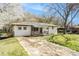 Quaint home features brick exterior, a front porch, and a long driveway with mature landscaping at 304 Mercer Dr, Jonesboro, GA 30236