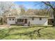 Charming brick home with a cozy front porch, set amidst a lush green lawn and mature trees at 304 Mercer Dr, Jonesboro, GA 30236
