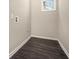 A small laundry area with gray walls, dark flooring, and a bright window at 304 Mercer Dr, Jonesboro, GA 30236