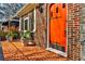 Inviting front porch with colorful tiled flooring and an orange front door featuring black wrought iron hardware at 1352 Emory Ne Rd, Atlanta, GA 30306