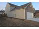 View of a home featuring a two-car garage, neutral siding, and large lawn at 1593 Maston Rd, Auburn, GA 30011