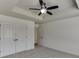 Bright bedroom featuring a ceiling fan, gray carpet, and a closet for ample storage space at 1952 Chapel Estates Ln, Dacula, GA 30019