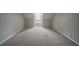 Neutral carpeted attic bedroom with small window with ledge at 6112 Shadow Rock Ln, Lithonia, GA 30058