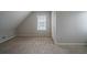 Neutral bedroom with large window, neutral carpet, and door to other rooms at 6112 Shadow Rock Ln, Lithonia, GA 30058