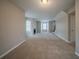 A large, open living room with many windows, fireplace and tan carpet at 6112 Shadow Rock Ln, Lithonia, GA 30058
