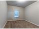 Neutral bedroom featuring plush carpet, a window, and a ceiling light at 1160 Faulkner Way, Jonesboro, GA 30238