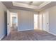 Bedroom with plush carpet, neutral walls, tray ceiling, and doorways to other rooms at 1160 Faulkner Way, Jonesboro, GA 30238