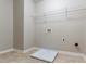 A bright laundry room has neutral tile floors, a wire rack, and hookups for machines at 1160 Faulkner Way, Jonesboro, GA 30238