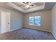 Bedroom with a large window, plush carpet, tray ceiling, and white trim at 1160 Faulkner Way, Jonesboro, GA 30238