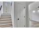 Modern staircase with wood treads, white risers, and natural light streaming through the glass door at 2954 Lighthouse Ct, Acworth, GA 30101