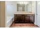 Bathroom with double vanity, dark wood cabinets, and a separate tub at 450 Lake Ridge Ln, Fairburn, GA 30213