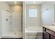 Bright bathroom featuring a walk-in shower, soaking tub, and vanity at 450 Lake Ridge Ln, Fairburn, GA 30213