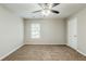 Bright bedroom featuring neutral walls, carpeted floor, ceiling fan, and a window for natural light at 450 Lake Ridge Ln, Fairburn, GA 30213