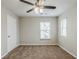 A carpeted bedroom features neutral colored walls, a ceiling fan, and a window for natural light at 450 Lake Ridge Ln, Fairburn, GA 30213