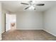 A carpeted bedroom includes a ceiling fan, neutral colored walls, and an open door at 450 Lake Ridge Ln, Fairburn, GA 30213