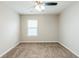 Neutral bedroom featuring carpet floors, ceiling fan, and window for natural light at 450 Lake Ridge Ln, Fairburn, GA 30213