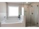 This bathroom boasts a soaking tub, stand-up shower, and a tiled shower with seamless glass door at 531 Eagles Nest Cir, Auburn, GA 30011
