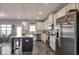 Bright kitchen featuring white cabinetry, stainless steel appliances, a center island, and wood-look flooring at 531 Eagles Nest Cir, Auburn, GA 30011