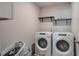Laundry room with side-by-side front-load machines and shelving at 531 Eagles Nest Cir, Auburn, GA 30011