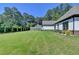 Well-manicured backyard with lush green grass, mature trees, and landscaping at 783 Blackberry Trl, Lawrenceville, GA 30043