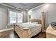 A neutral primary bedroom features a four-poster bed, wood floors, and bright window at 783 Blackberry Trl, Lawrenceville, GA 30043