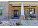 Welcoming front porch with stone accents, wrought iron double doors, and decorative landscaping at 783 Blackberry Trl, Lawrenceville, GA 30043