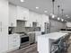 Modern kitchen with white cabinets, stainless steel appliances, island seating, and hardwood floors at 783 Blackberry Trl, Lawrenceville, GA 30043