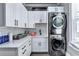 Bright laundry room with modern appliances, white cabinetry and countertops, and a sink at 783 Blackberry Trl, Lawrenceville, GA 30043