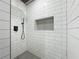 Modern shower featuring sleek white tile, a rainfall showerhead, and built-in niche at 783 Blackberry Trl, Lawrenceville, GA 30043