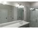 Modern bathroom featuring a large mirror, dual-faucet sink, gray cabinets, and marble-tiled shower at 2008 Main Nw St, Atlanta, GA 30318