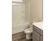 Bright bathroom with a tub and shower combo, grey vanity, quartz countertop, and open toilet seat at 2008 Main Nw St, Atlanta, GA 30318