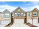 Charming townhomes featuring brick and siding exteriors with attached garages, set under a bright blue sky at 2230 Mulsanne Dr, Lithonia, GA 30058