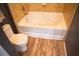 Bathroom showcasing a deep soaking tub, tile wall surround, and a toilet, perfect for relaxation and comfort at 898 Oak Sw St # 1410, Atlanta, GA 30310