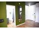 Hallway features wood-look floors, olive-colored accent wall, modern fixtures, and entrance to the bathroom and kitchen at 898 Oak Sw St # 1410, Atlanta, GA 30310