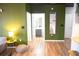 Stylish hallway with green accent wall leads to a modern bathroom with gray vanity and wood-look floors at 898 Oak Sw St # 1410, Atlanta, GA 30310