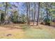 A sprawling backyard bordered by mature trees and wooden fences, ideal for outdoor activities at 9090 Dorsey Rd, Riverdale, GA 30274