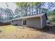 This home features a spacious backyard with mature trees, a sliding glass door, and a fenced perimeter at 9090 Dorsey Rd, Riverdale, GA 30274