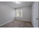 This bedroom features neutral walls, carpeted floors, a window and closet at 9090 Dorsey Rd, Riverdale, GA 30274