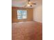 Large bedroom with a ceiling fan and a view of the backyard through the window at 2030 Calmwater Ct, Suwanee, GA 30024