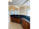Well-lit kitchen with dark countertops, wooden cabinets, and an adjacent dining area at 2030 Calmwater Ct, Suwanee, GA 30024