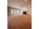 Open-plan living area with a fireplace, multiple windows, and neutral carpeting at 2030 Calmwater Ct, Suwanee, GA 30024