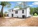 Side and rear view of a bright, white home with a newly paved patio and an expansive, mostly cleared backyard at 6539 Hayes Dr, Riverdale, GA 30274