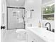 Modern bathroom features white marble tiling, glass shower doors, and matte black hardware at 6539 Hayes Dr, Riverdale, GA 30274