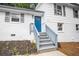 Close up shot of a freshly landscaped yard with a blue door at the front entrance and gray stairs at 6539 Hayes Dr, Riverdale, GA 30274