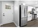 Modern kitchen featuring stainless steel appliances, white cabinets, and a stylish refrigerator at 6539 Hayes Dr, Riverdale, GA 30274