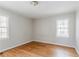 Bedroom with hardwood floors, neutral paint, and natural light from two windows at 1579 Mayflower Sw Ave, Atlanta, GA 30311