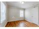 Bright bedroom featuring hardwood floors, a window, and a door at 1579 Mayflower Sw Ave, Atlanta, GA 30311