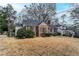 View of a charming brick home with mature landscaping and well-maintained lawn at 1579 Mayflower Sw Ave, Atlanta, GA 30311